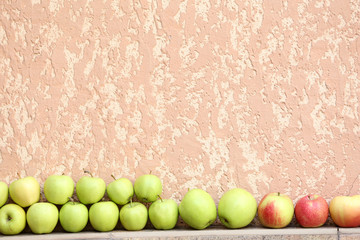 Juicy apples in row on wall background