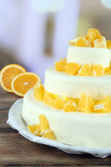 Beautiful wedding cake with oranges on  light background