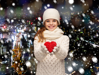 dreaming girl in winter clothes with red heart