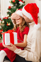 smiling father surprises daughter with gift box