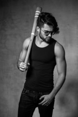 sexy fashion man model with a baseball bat posing dramatic