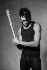 sexy fashion man model with a baseball bat posing dramatic