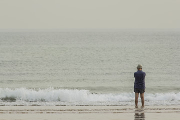 Fototapeta na wymiar Hombre con sombrero en la orilla del mar