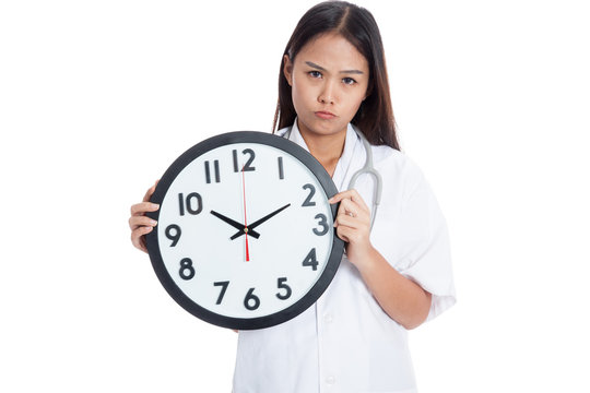 Frustrated Young Asian female doctor with a clock