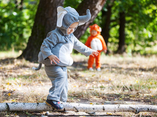 Two toddler boys dressed in animal costumes in park
