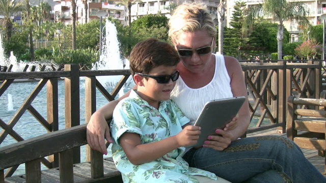 Mother and son using digital tablet outdoor