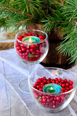 Candles in glasses with cranberries