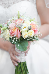 Obraz na płótnie Canvas Hands of a bride holding a bouquet
