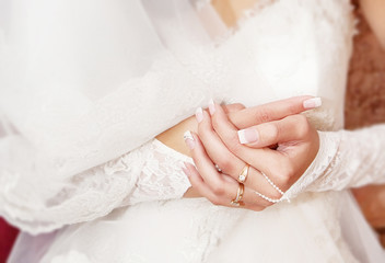 Obraz na płótnie Canvas hands of bride over the dress closeup