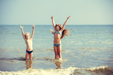 happy little girl and boy in the sea