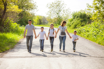 parents and their children walking in the forest on summer day