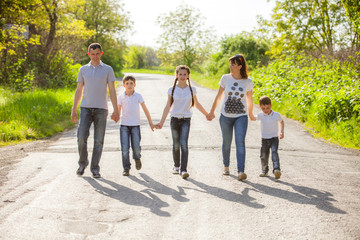 parents and their children walking in the forest on summer day