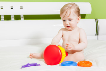 cheerful little kid boy playing with colorful toy