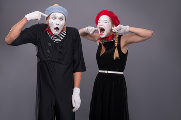 Portrait of funny mime couple with white faces and emotions isol