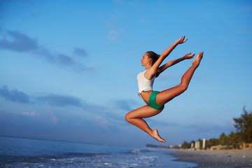 Fototapeta na wymiar Girl jumping at sunrise or sunset