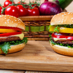 homemade hamburger with fresh vegetables on cutting board