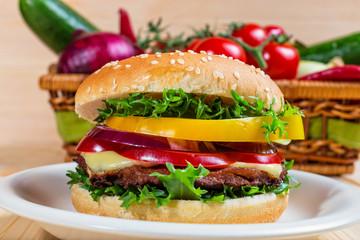 homemade hamburger with fresh vegetables on cutting board