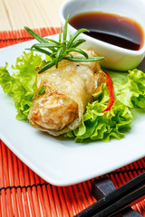 fried spring rolls on red bamboo mat