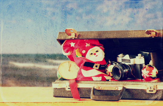 open briefcase with christmas decorations and camera in front of