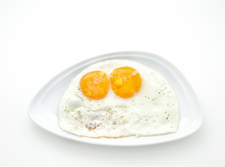 Two scrambled eggs on a white plate