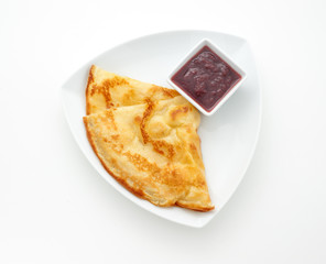 Pancake with strawberry jam on a white plate