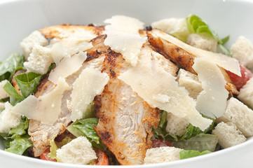 Caesar salad with cheese on white plate