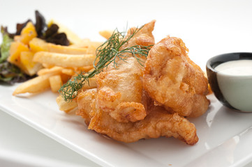 Pieces of chicken fried in batter witn french fries and salad