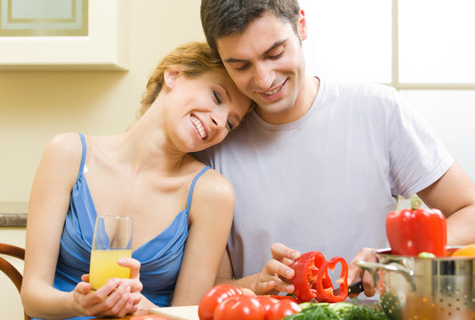 Cheerful young cooking couple at home