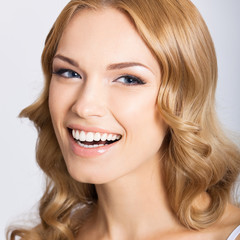 Naklejka premium Young cheerful smiling woman, on gray