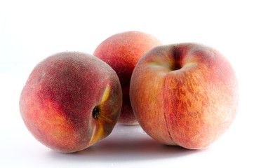 three ripe peaches isolated on white background