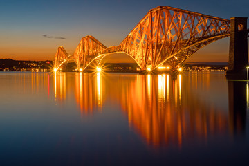 The illuminated Forth rail bridge in Scotland