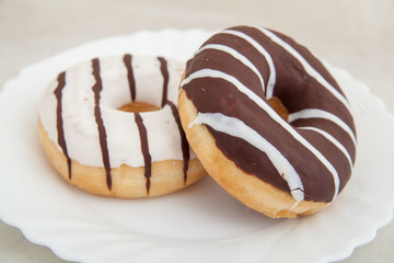 Two fresh donuts on white plate