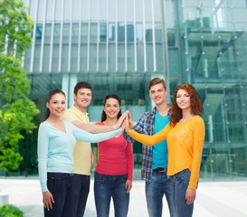 smiling teenagers making high five