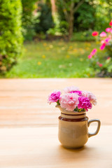 Pink carnation flowers in small ceramic vase