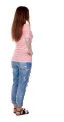 Obraz premium back view of standing young beautiful redhead woman.
