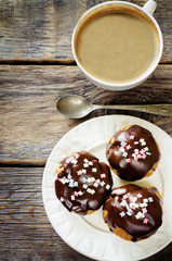 profiteroles with chocolate icing and colored powder and coffee