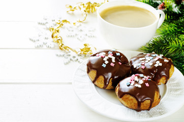 profiteroles with chocolate icing and colored powder and coffee