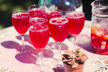 Beautiful line of different coloured cocktails on a open air par