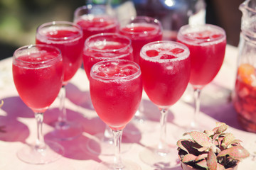 Beautiful line of different coloured cocktails on a open air par