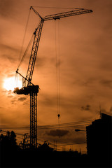 Silhouetted construction crane in the evening