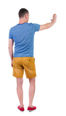 back view of man. Young man in shorts presses down on something