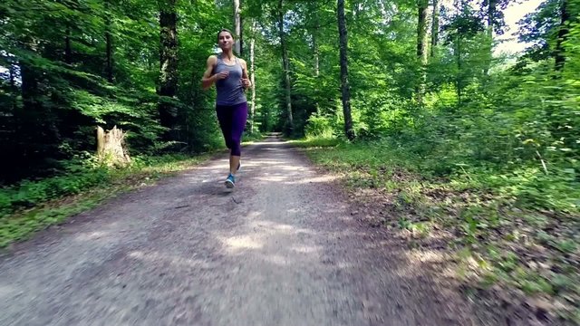 young woman jogging through forest