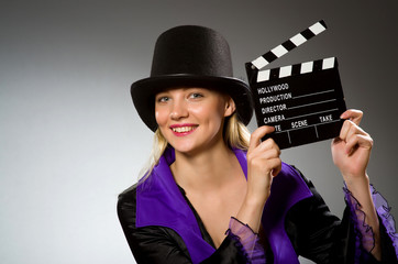Woman with movie clapboard against grey background