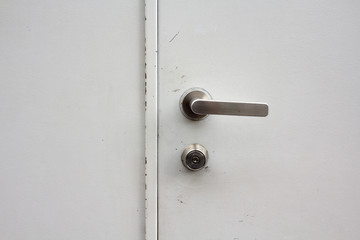a door knob on a white door and a white wall.