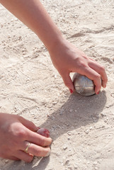  Hands picking up a petanque ball and the jack