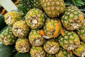 Lots of pineapples on supermarket stall