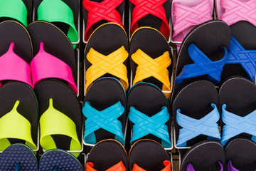Colorful of flat shoes hanging on shelf for sale.