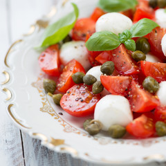 Close-up of caprese salad with capers and fresh mint, close-up