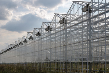 Industrial greenhouses on the sky background with clouds