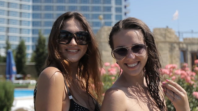 Two young girls in swimsuits temptingly move, indulge and laugh